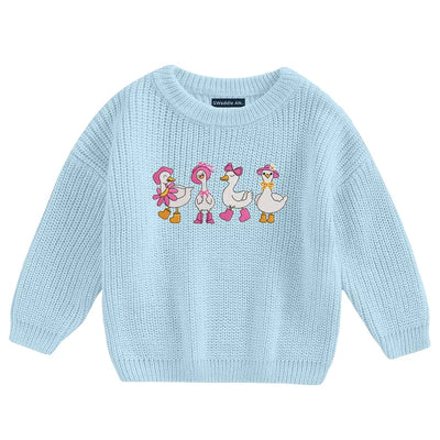 Light blue sweater with cartoon duck design on a white background