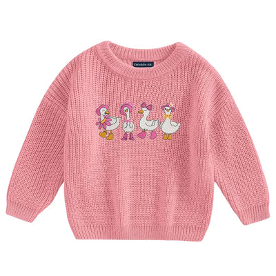 Pink sweater with embroidered ducks on a white background