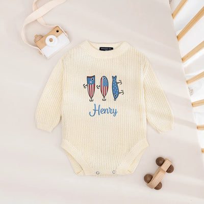 Baby onesie with colorful fish design and 'Henry' text on a light background