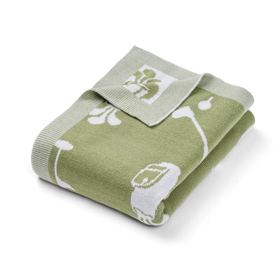 Green baby blanket with white patterns on a white background