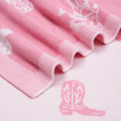 Close-up of pink fabric with white embroidery and a pink boot design.