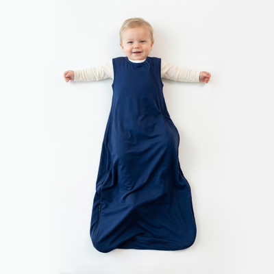 Child wearing a blue depths sleep sack on a white background
