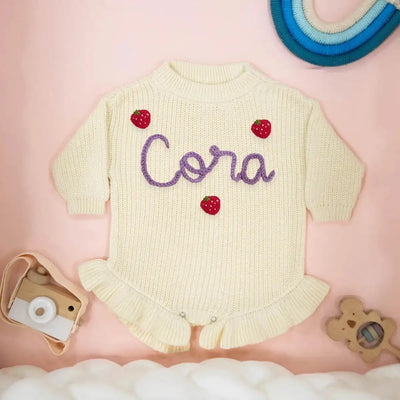 Baby romper with 'Cora' embroidered on a pink background