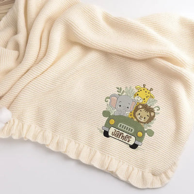 Cream personalized ruffle knitted baby blanket with embroidered design of woodlamd adventure awaits and name 'James'.