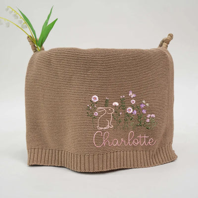 Personalized baby blanket with embroidered bunny floral design and 'Charlotte' text on a white background
