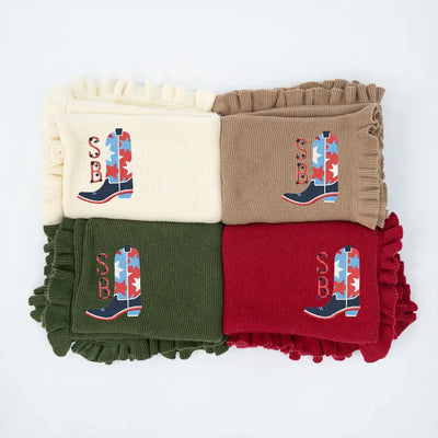 Four personalized baby blankets in white, brown, green, and red with embroidered usa star cowboy boot designs on a white background.