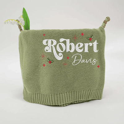 Sage green personalized baby blanket with embroidered names 'Robert' and 'Davis' on a white background